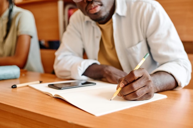 Student writing exam at desk