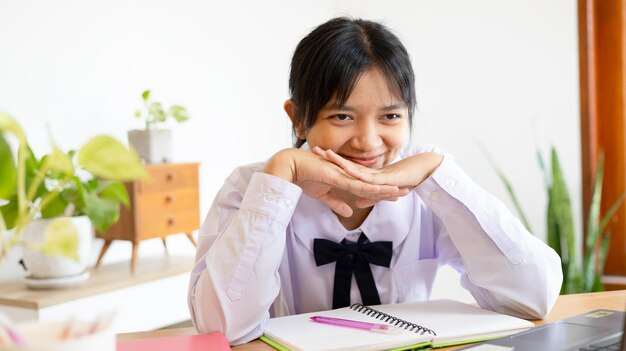 写真 家でラップトップで勉強する学生の少女はオンラインで