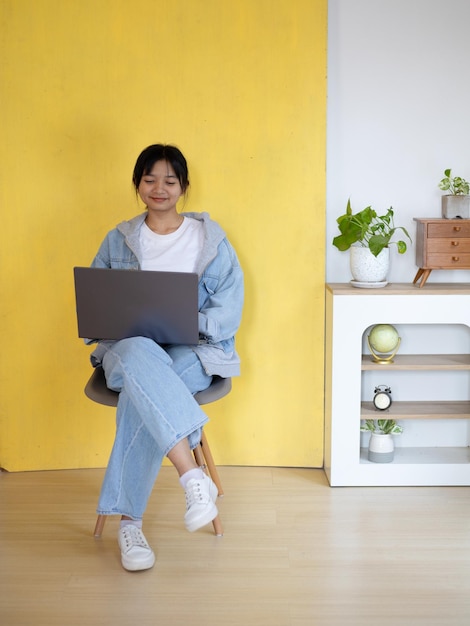 Photo student young girl using laptop and siting on chair