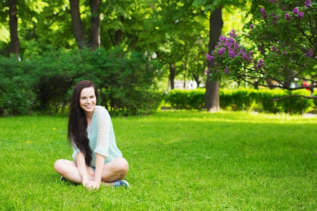 Studente het glimlachen zitting op het gras