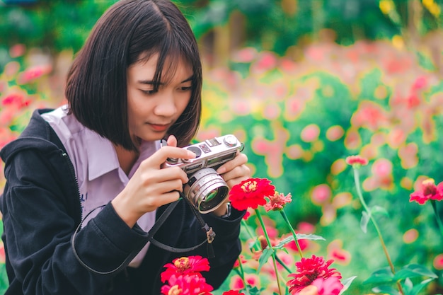 Studente met uitstekende camera in de bloemtuin