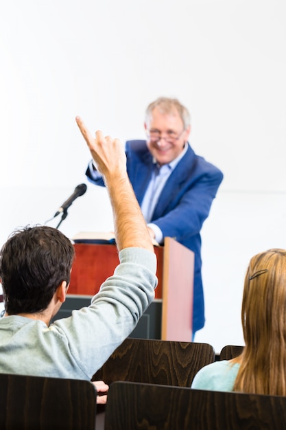 Studenten die aan universiteitsprofessor luisteren die lezing geeft