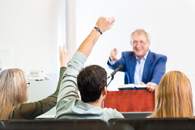 Studenten die aan universiteitsprofessor luisteren die lezing geeft