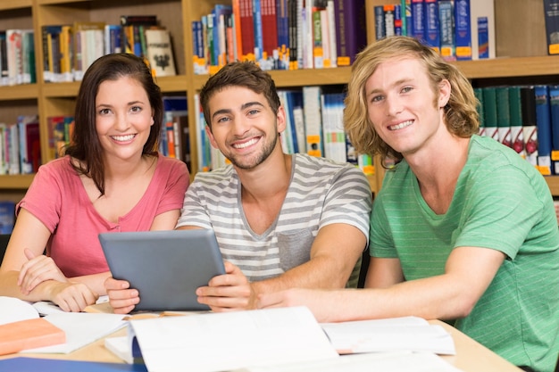 Studenten die digitale tablet in bibliotheek gebruiken