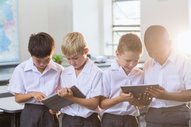 Studenten die digitale tablet in klaslokaal gebruiken