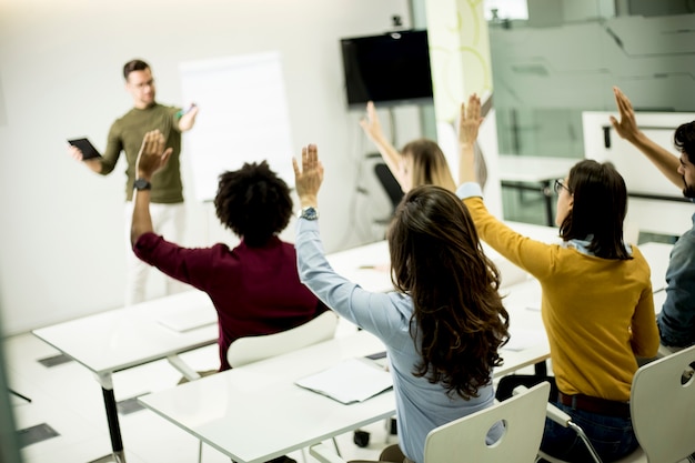 Studenten die handen opstaan om de vraag tijdens de workshoptraining te beantwoorden