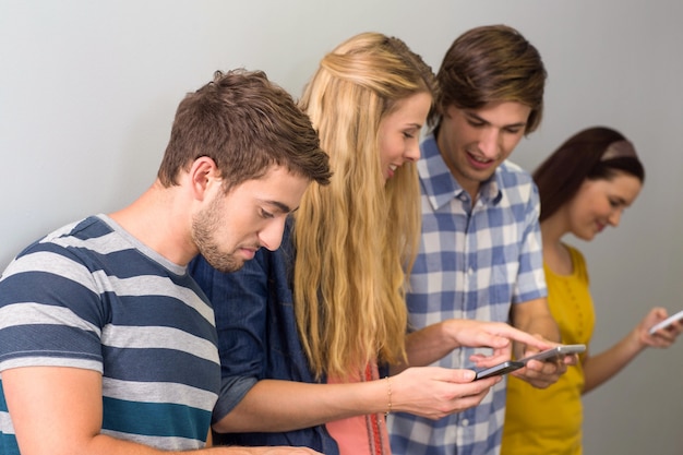 Foto studenten die mobiele telefoons gebruiken