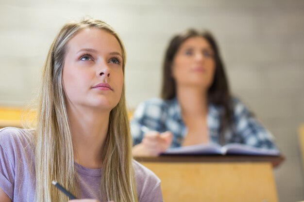 Studenten die naast elkaar zitten tijdens het leren op de universiteit