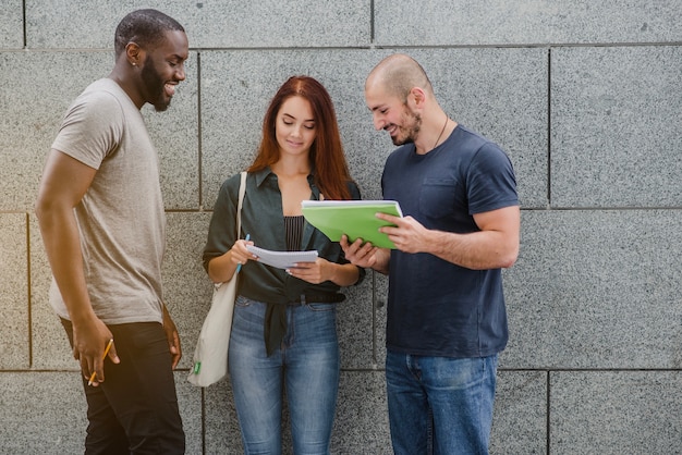 Foto studenten die notitieblokken houden staan ​​lachend