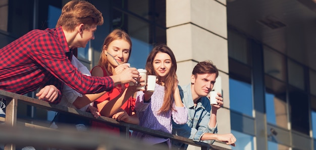 Studenten genieten van een kopje koffie om op straat te gaan. Jongeren in de ochtend buiten met kopje energiedrank