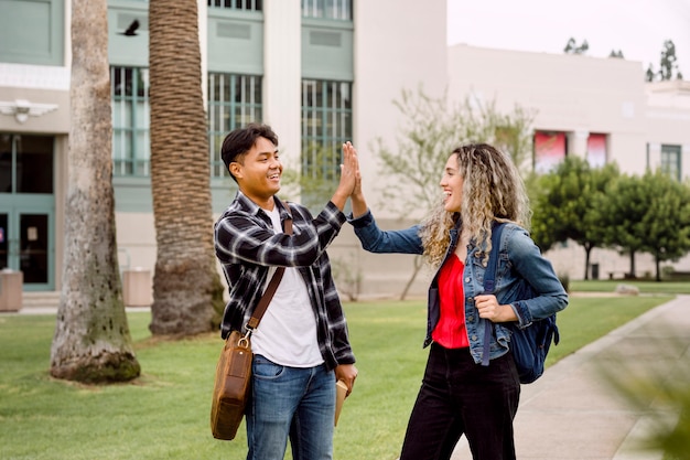 Foto studenten geven high five op de universiteit