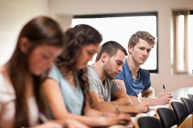 Studenten luisteren een docent met de focus van de camera op de voorgrond