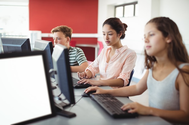 Studenten met behulp van computer in de klas