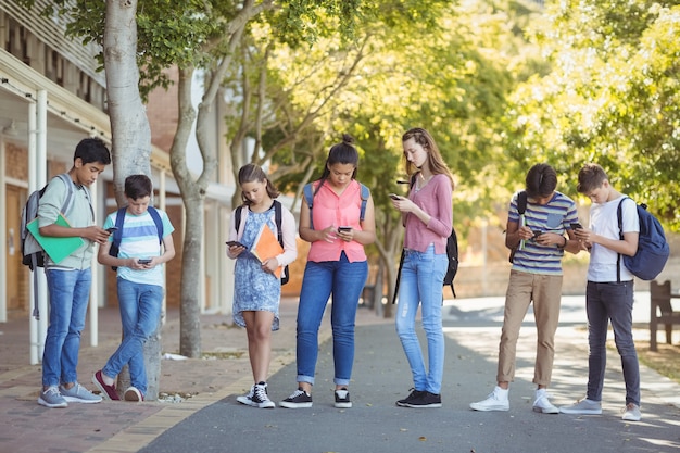 Studenten met behulp van mobiele telefoon onderweg op de campus