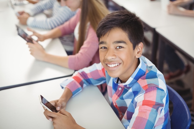 Studenten met digitale tablet en mobiele telefoon in de klas