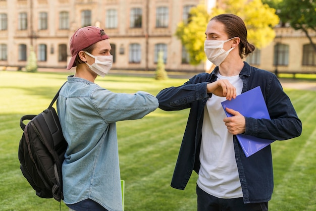 Studenten met gezichtsmaskers begroeten elkaar