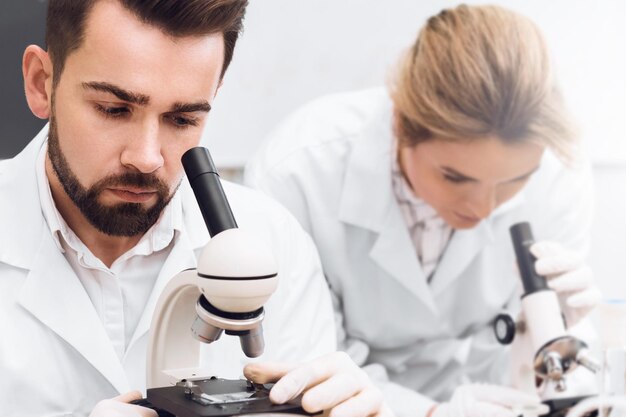 Studenten werken in een laboratorium met behulp van microscopen tijdens wetenschappelijk onderzoekswerk