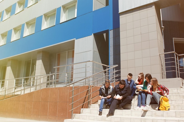 Studenten zitten en studeren op de veranda van de universiteit