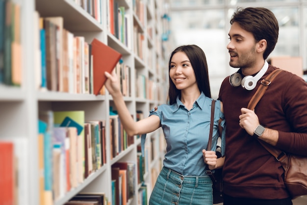 Studenten zoeken boeken in de bibliotheek.