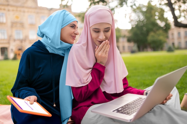 Studenten zoeken informatie. Internationale moslimstudenten zoeken informatie op internet terwijl ze buiten zitten