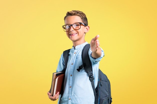 Studentenjongen met rugzak en glazenhandenschudden na goede overeenkomst. terug naar school