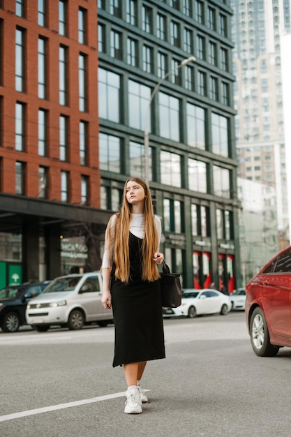 Studentenmeisje dat over straat loopt op een achtergrond van stadsgezicht