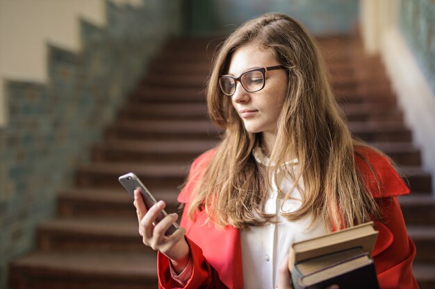 Studentenmeisje die haar smartphone controleren