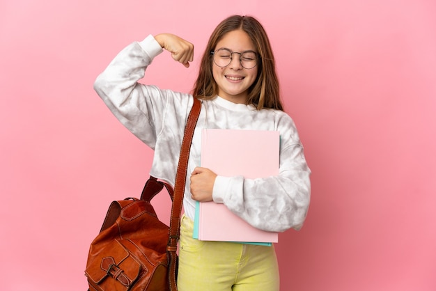 Studentenmeisje over geïsoleerde roze muur die sterk gebaar doet