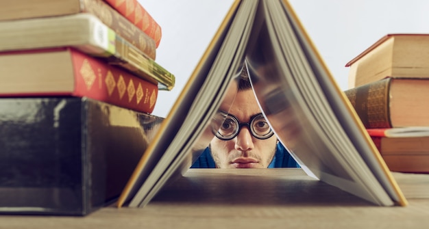 Foto studentjongen berispt op school verborgen tussen boeken