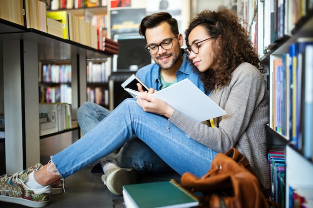 学生たちは図書館で一緒に勉強しています。カップル、研究、技術、教育愛の概念