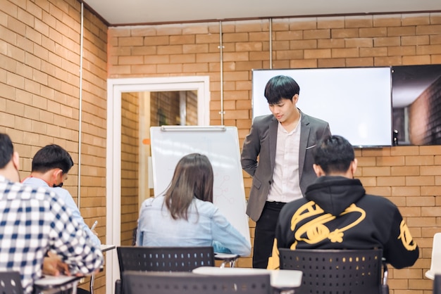 사진 학생들은 학기말에 성적을 받기 위해 시험을 치르고 있습니다. 그리고 교실에는 시험을 감독하는 젊은 교사가 있습니다.