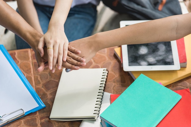 Foto studenti college stacking hand success che mostra l'unità del lavoro di squadra