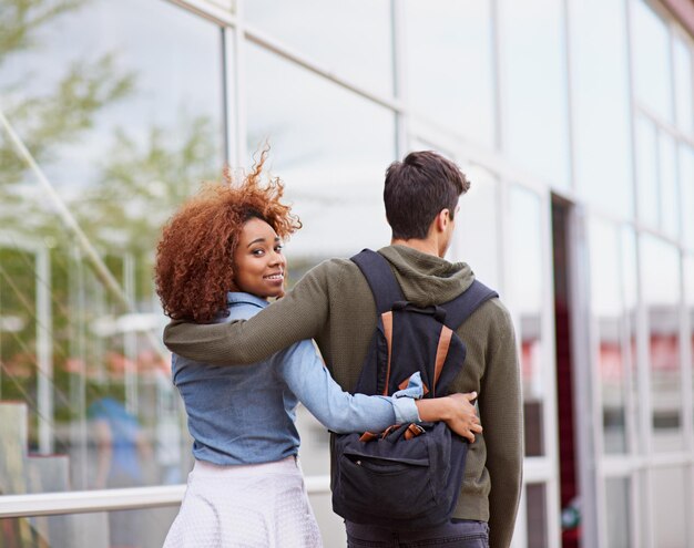 Photo students couple and walking on campus for university love and study with portrait or hug man woman and strolling outdoor at school for college relationship and education with face or backpack