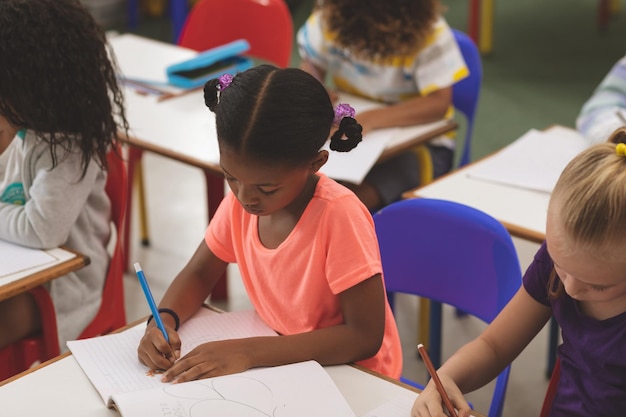 Photo students drawing on notebook in classroom