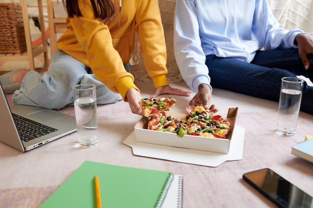 Foto studenti che mangiano pizza suprema