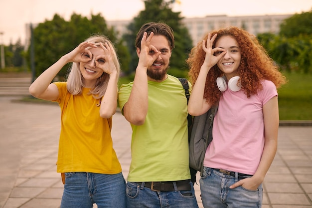 Foto studenti che gesticolano ok vicino agli occhi