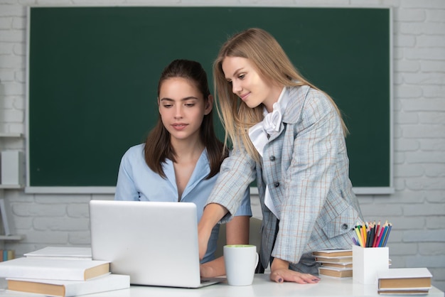 Студенты подруги смотрят на ноутбук в классе в школьном колледже или университете на бл