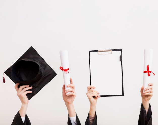 Photo students holding certificates and toga