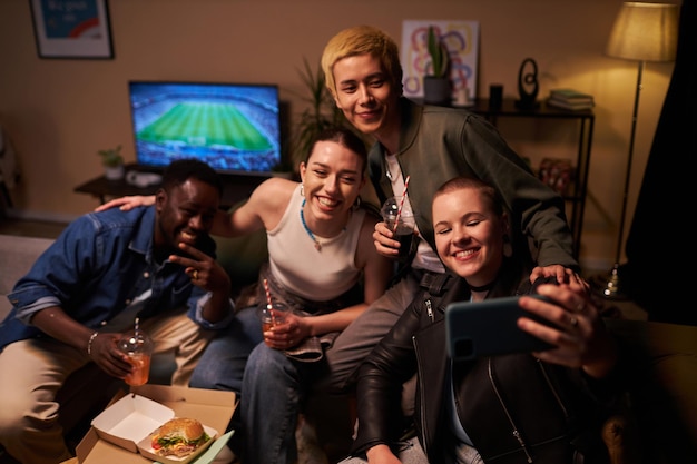 Foto studenti a casa a festeggiare con il fast food che si fanno un selfie