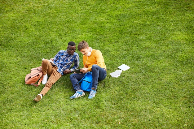 Students Relaxing on Green Grass