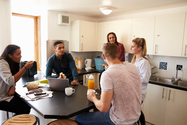 students relaxing in kitchen of shared accommodation