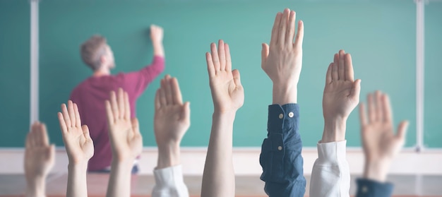 Photo the students at school with raised handsãâ± classroom learning together