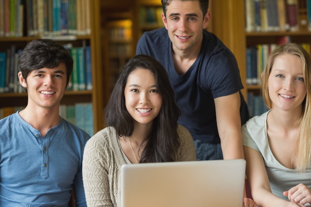 Photo students sitting at the library while smiling