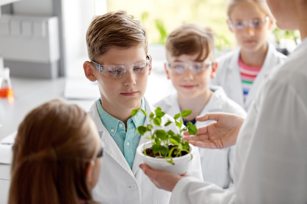 Foto studenti e insegnanti con piante alla lezione di biologia