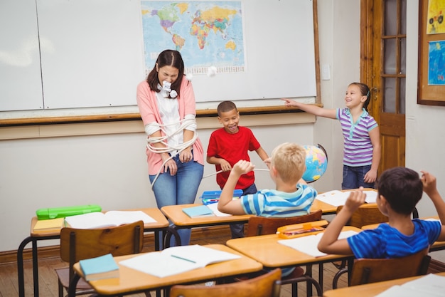 Students thorwing paper and airplanes at the teacher