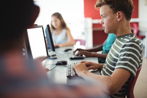 Photo students using computer in classroom