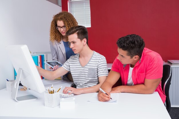 Students using computer together and taking notes