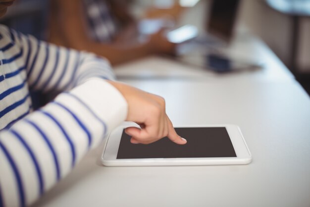 Students using digital tablet and laptop in classroom