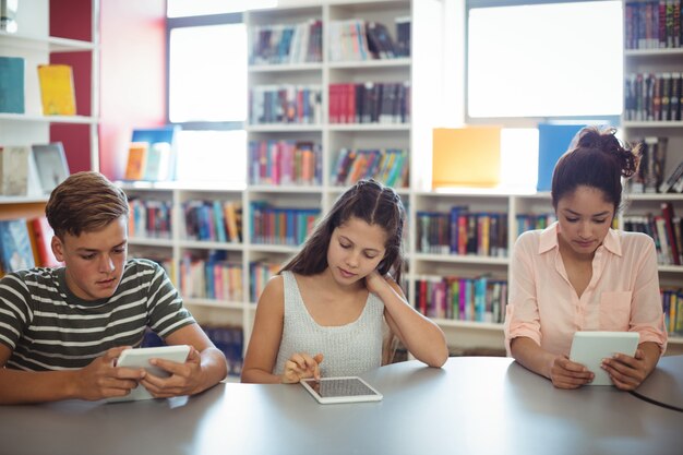 Students using digital tablet in library