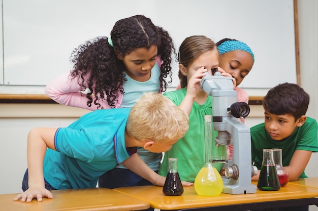 科学ビーカーと顕微鏡を使用している学生